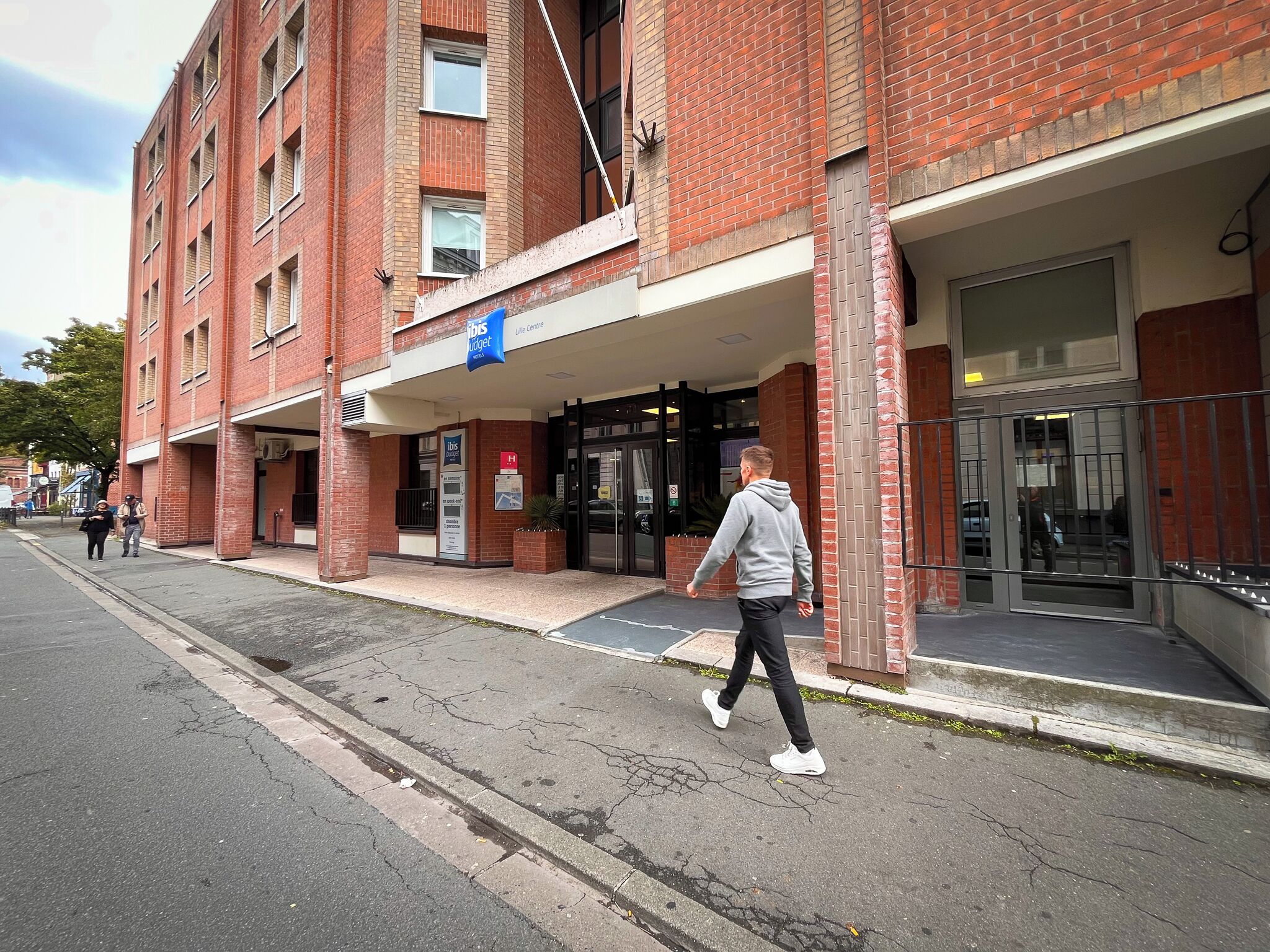 Un bâtiment en briques rouges sur lequel on peut lire l’enseigne « Ibis Budget Life Centre ».