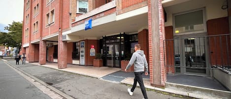 A red brick building with a sign for 'Ibis Budget Life Centre'.