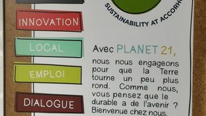 Eine Schwarze Tafel mit einem Schild für 'Planet 21', das Nachhaltigkeit bewirbt.