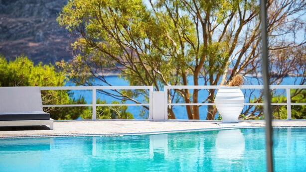 A pool area with a view of a mountain and trees. - Akra Morea Hotel & Residences by GHH (Monemvasia)