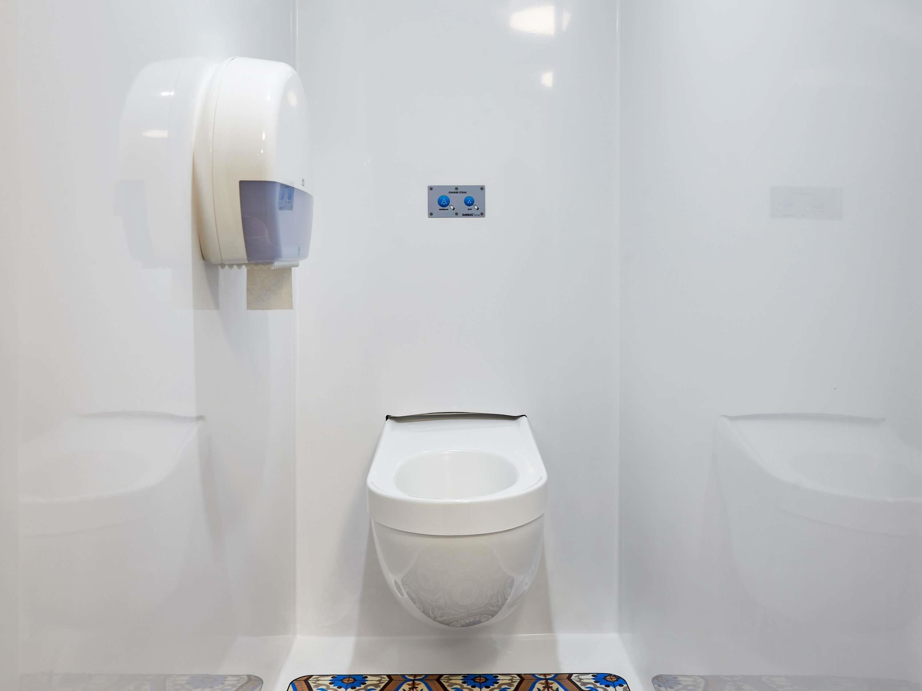 Un bagno moderno con un water, un asciugamani ad aria e un bidet.