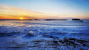 A frozen lake with a sunset in the background.