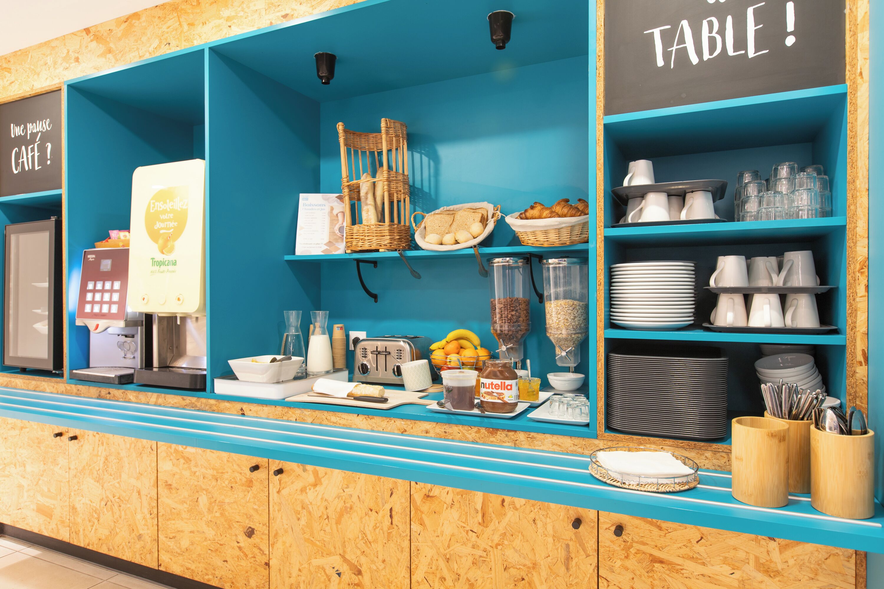 A breakfast bar with a coffee machine, toaster, and various breakfast items.