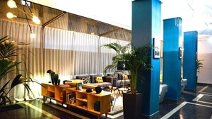 A modern lobby with a sofa, coffee table, and potted plants. - Hôtel GAUTHIER (Casablanca)