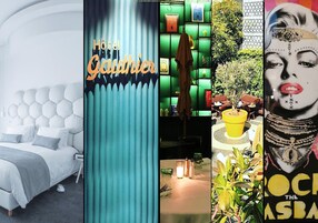 Modernilla designilla sisustettu hotellihuone, jossa on muun muassa patinoidulla päätyosalla varustettu sänky, vihreä tehosteseinä ja ruokailualue, jossa on kahdelle katettu pöytä.