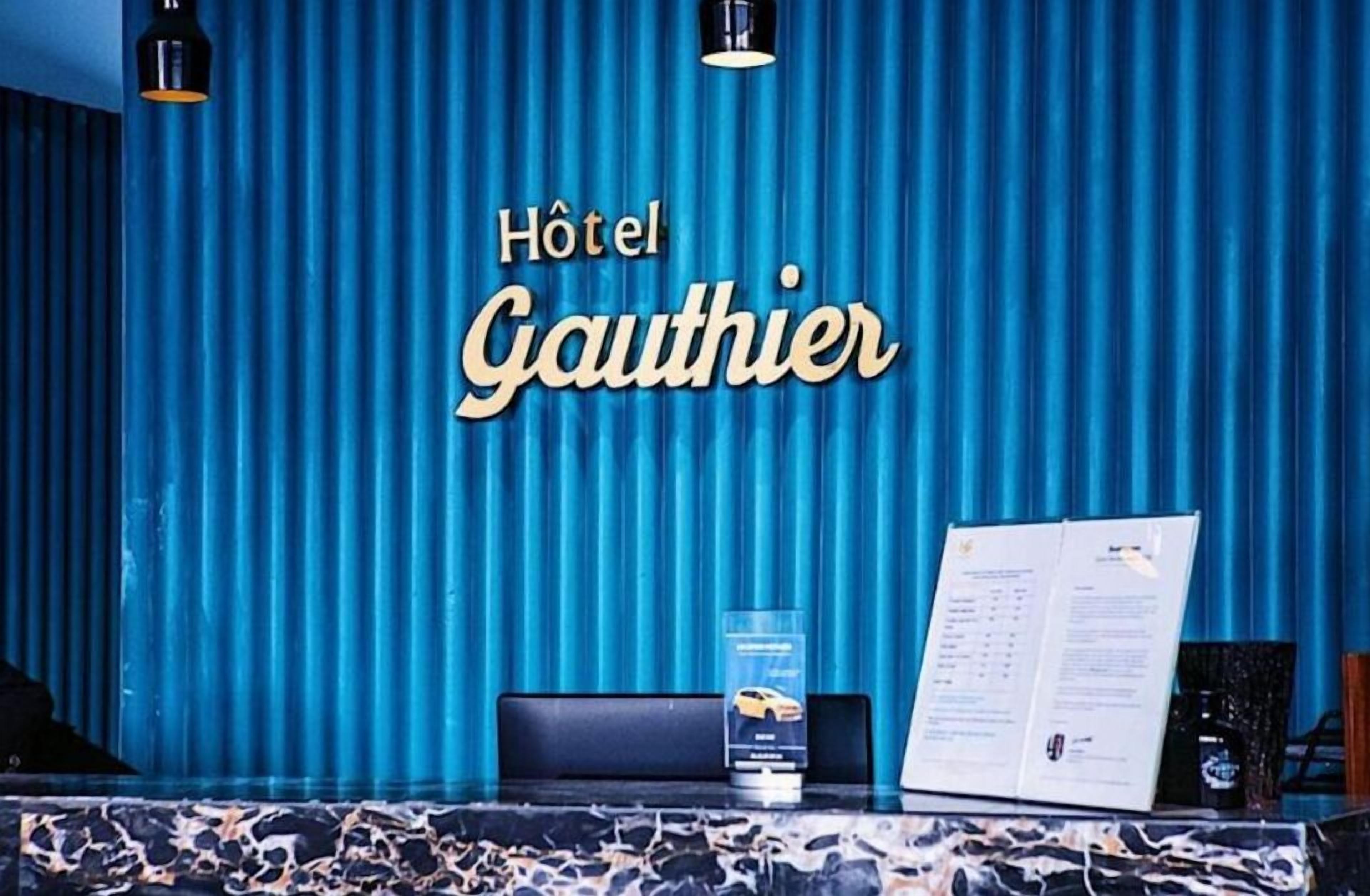 A hotel reception desk with a blue curtain backdrop, a menu, and a car service brochure.