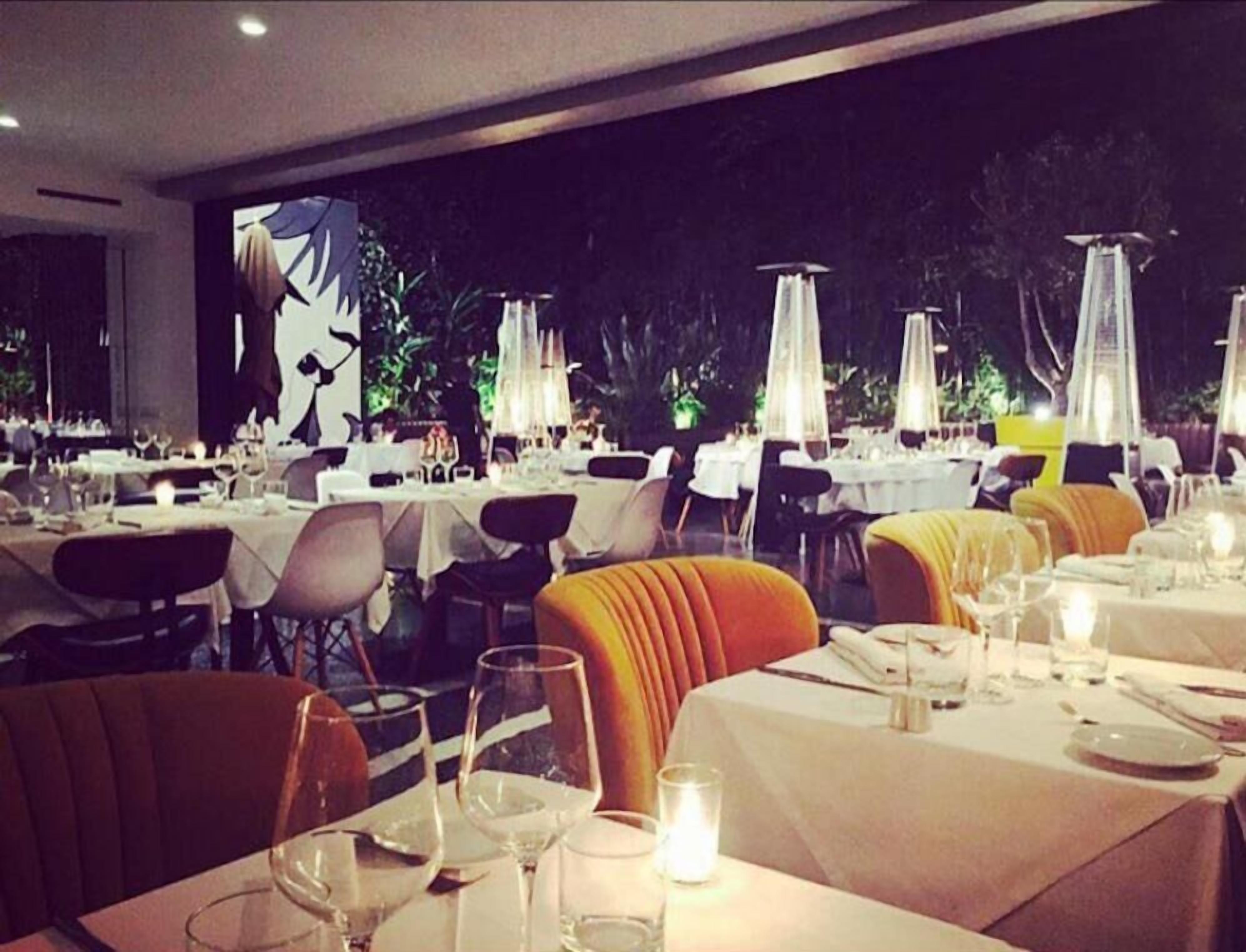 A restaurant with tables set for dining, featuring a view of the outdoors.