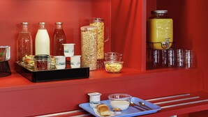 A red buffet setup with various food items and beverages. - hotelF1 Lyon Sud Oullins (Oullins)