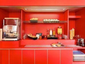 A red buffet area with a coffee machine, pastries, condiments, and beverages. - hotelF1 Poitiers Nord Futuroscope (Chasseneuil-du-Poitou)