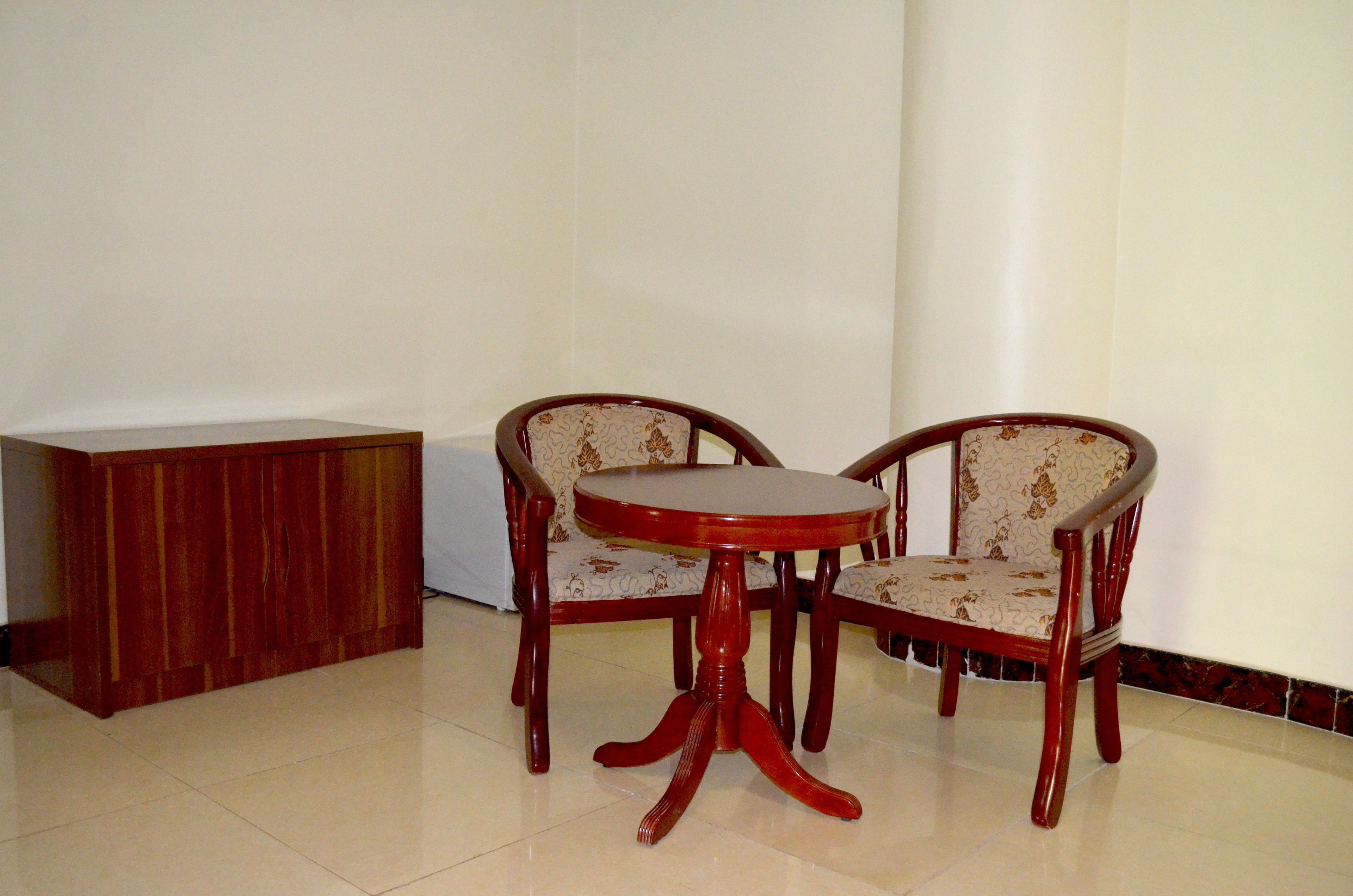 A dining area with a wooden table and two chairs with patterned upholstery.