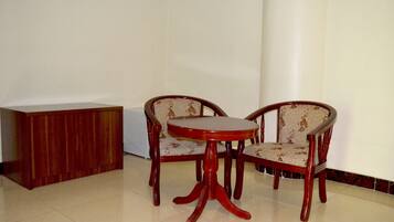 A dining area with a wooden table and two chairs with patterned upholstery.