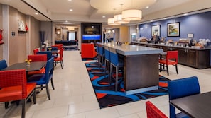 Relax and socialize in our welcoming lobby, featuring a central bar, seating area, and entertainment options.