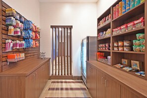 A narrow hallway with wooden cabinets on either side, stocked with various snacks and beverages. - Holiday Inn Express & Suites Uniontown by IHG (Uniontown)