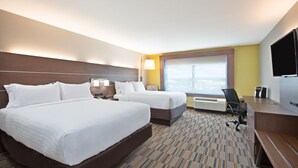 A hotel room with two beds, a desk, a chair, a TV, and a large window.