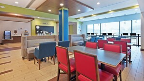 A modern restaurant with booths and tables, a coffee station, and a view through large windows.