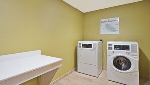 A laundry room with two washing machines and a sink.