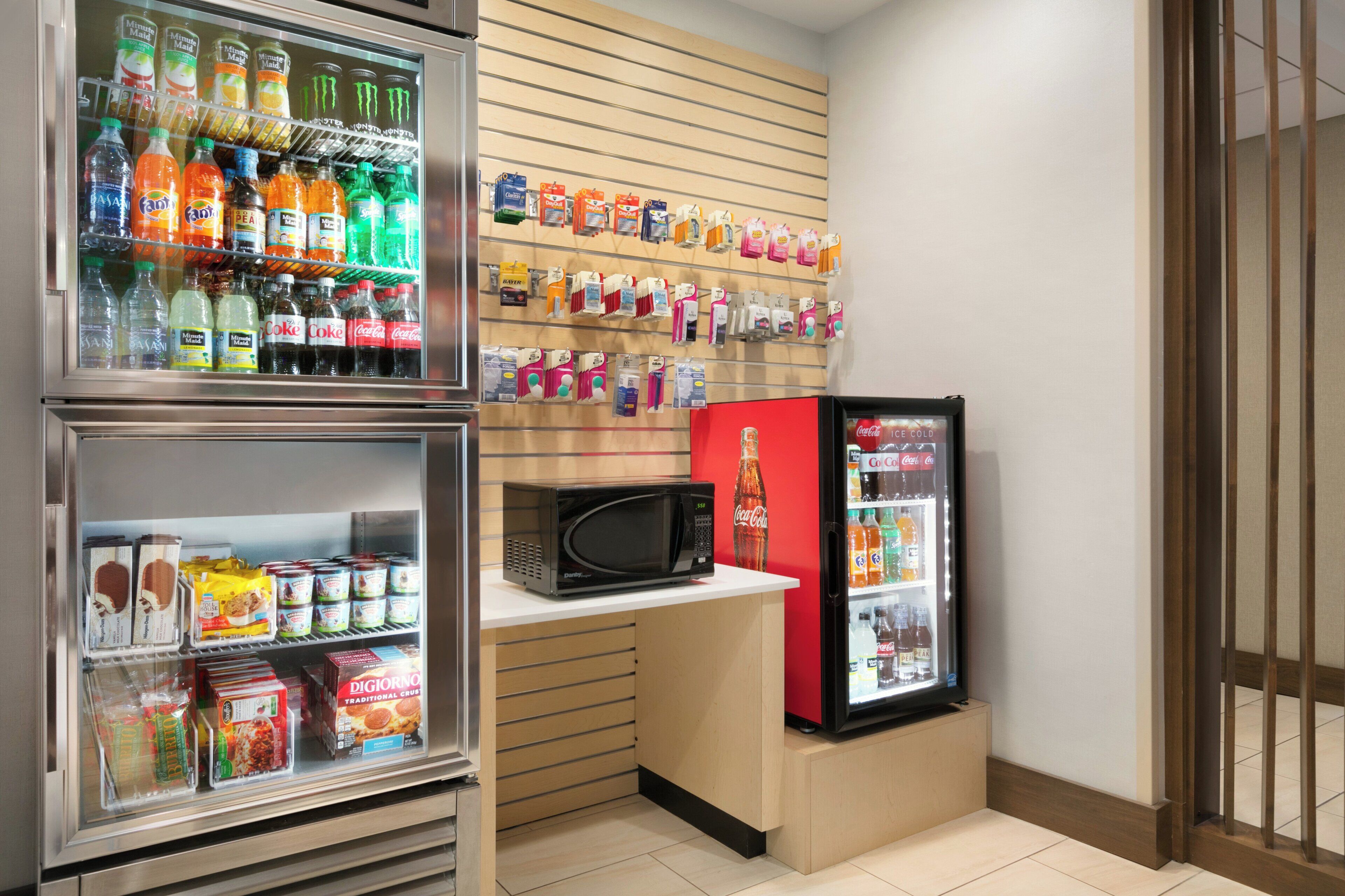 A kitchenette with a refrigerator, microwave, and a beverage cooler.