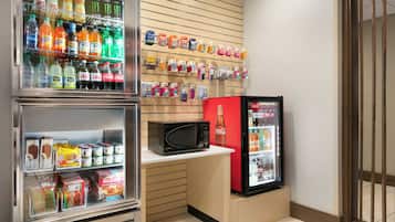 A kitchenette with a refrigerator, microwave, and a beverage cooler.