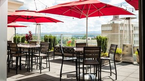 Une terrasse extérieure avec des parasols rouges, des tables et des chaises.