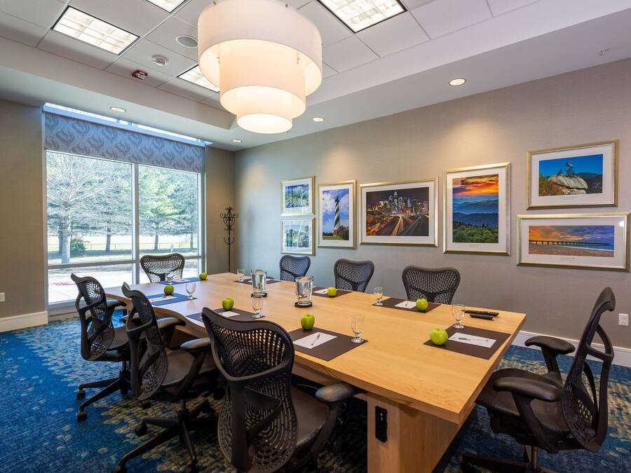 A conference room with a long table, chairs, and framed pictures on the wall.
