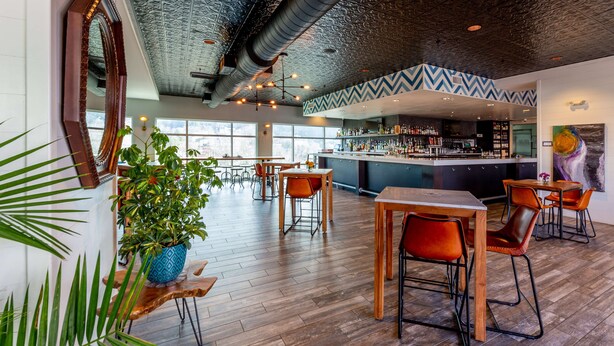 Un grand espace bar doté d’un comptoir moderne et de nombreux sièges.