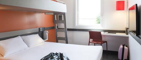 Una cama litera con escalera, un escritorio con silla, un televisor y una maleta.