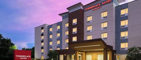 Un hotel TownePlace Suites Marriott con un diseño moderno, que cuenta con una entrada destacada y una fachada bien iluminada.