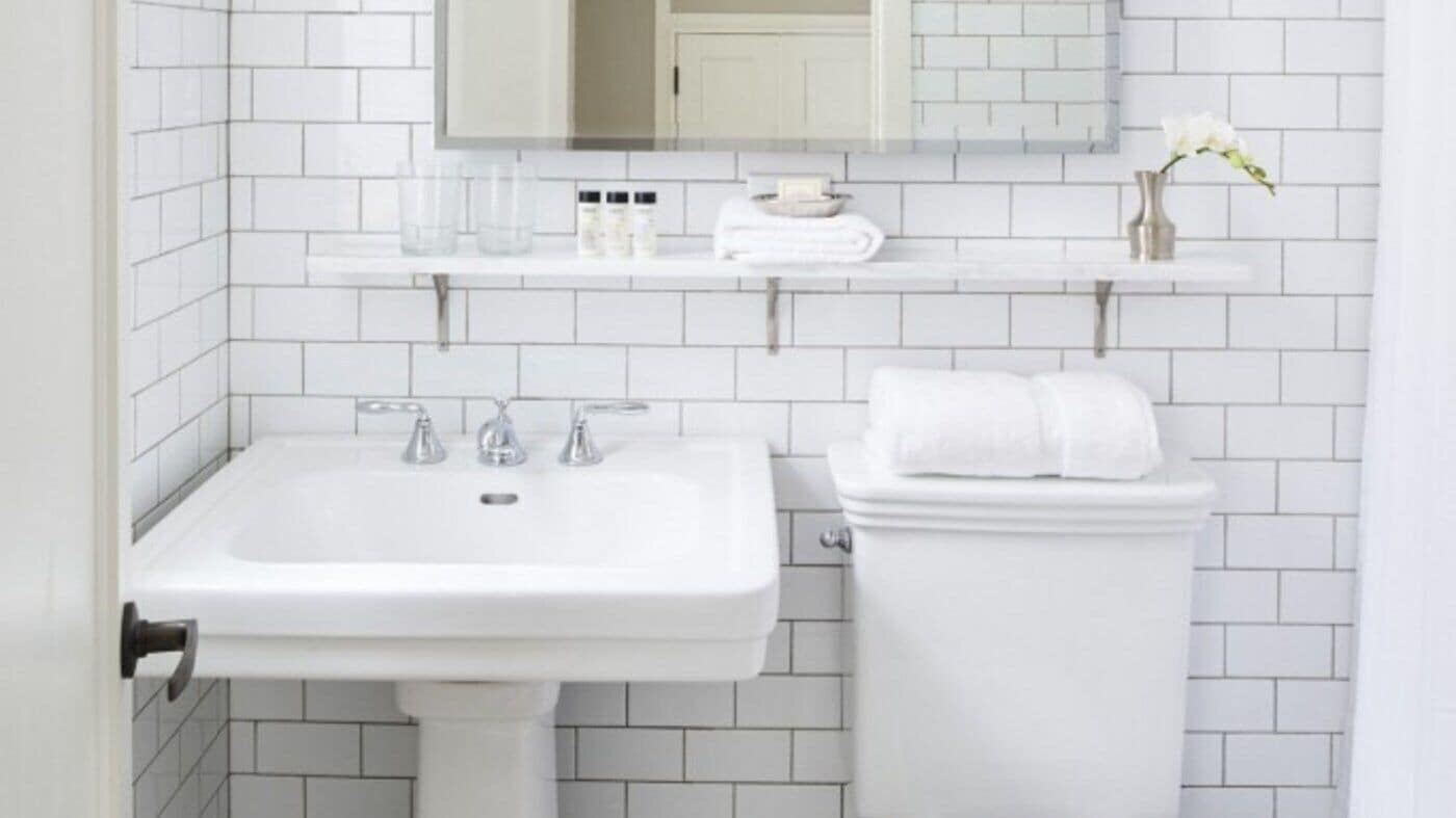 A bathroom with a white sink, toilet, and mirror.