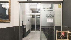 A hotel entrance with a staircase leading to a room labeled "SLOW SUITES." - Slow Suites Augusto (Madrid)