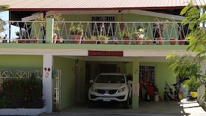 Un edificio de dos pisos con un cartel que dice "THE REDHUT INN" sobre la entrada.