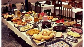 Uma mesa de buffet com diversos alimentos e bebidas.