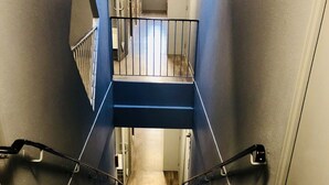 A staircase with a handrail, wooden steps, and a white mat at the bottom. - hotelF1 Geneve Ferney Airport (Ferney-Voltaire)