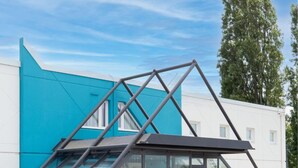 A modern building with a glass facade and a metal framework structure. - Kyriad ECO - Moulins Sud Yzeure (Yzeure)