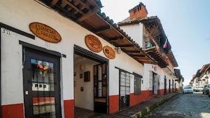 Een gebouw met borden voor 'Estancias El Paraiso' en 'Rancho Solano Hotel'.