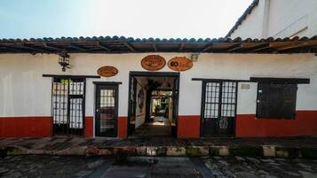A building with a tiled roof, a central entrance, and two doors on either side.