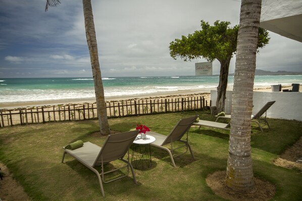 Rannalla, valkoista hiekkaa, aurinkotuoleja, rantapyyhkeitä