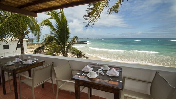 Ein Tisch für zwei mit Blick auf den Ozean und den Strand.