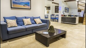 A living room with a sofa, coffee table, and a painting on the wall.