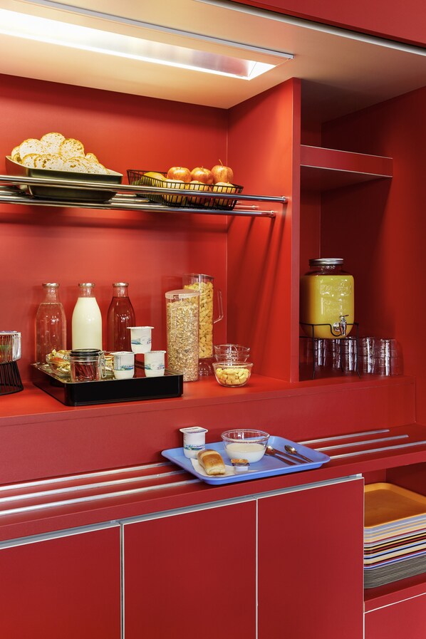 Un buffet rouge, agrémenté de divers plats et boissons.
