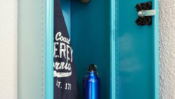 A blue door with a towel hanging on the left side and a blue water bottle in front.