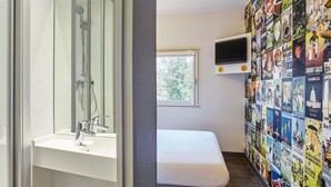Un baño moderno con cabina de ducha de vidrio, un lavabo blanco y un banco.