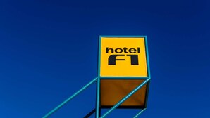 Un panneau jaune sur lequel on peut lire les mots « hôtel » et « FT », fixé sur une structure métallique bleue.