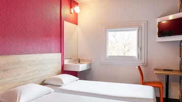 Ein Zimmer mit Bett, Fenster, Waschbecken und Stuhl.