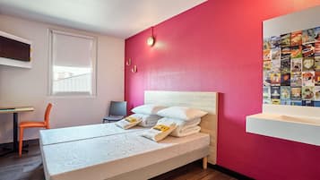 Ein modernes Schlafzimmer mit Bett, Schreibtisch und Stuhl.