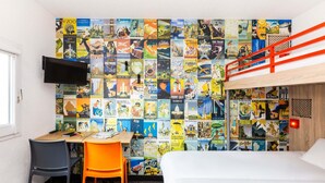 Une chambre avec un lit superposé, un bureau avec une chaise et un mur recouvert d’affiches de voyage.