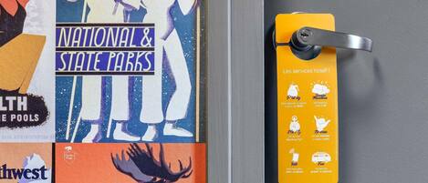 A door with a yellow sign detailing hotel services, including Wi-Fi, parking, and a 24-hour reception.