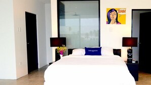 A modern hotel room with a large bed, two bedside tables with lamps, a large window, and a poster on the wall. - The Marion Villa (Scarborough)