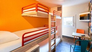 Habitación con literas, un escritorio, una silla, un ventanal y un televisor en la pared.