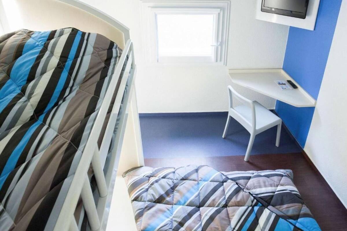 A room with a bed, a desk, and a television.