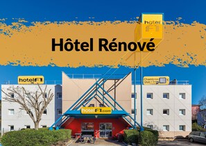 A hotel with a modern facade, a prominent entrance with a blue and red color scheme, and signage indicating it is a hotel. - hotelF1 St Witz A1 Paris Nord (Saint-Witz)